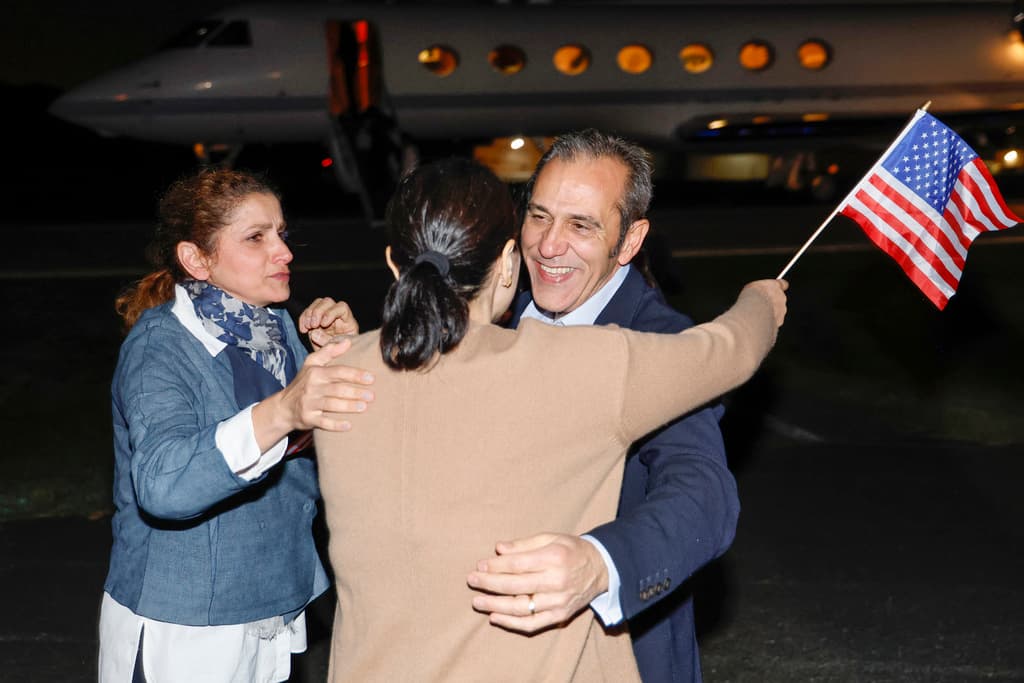 Jonathan Ernst/pool via AP Family members embrace freed American Emad Shargi as he arrives at Davison Army Airfield, September 19, 2023 at Fort Belvoir, Virginia.